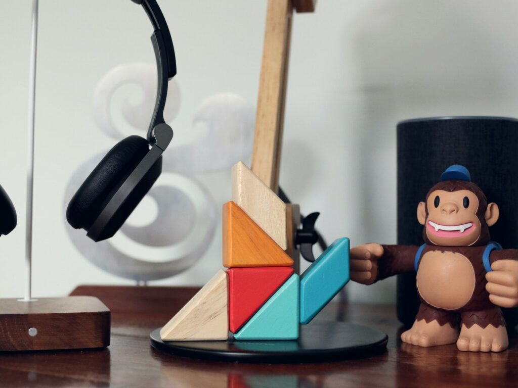 Coloured blocks, headphones and toy gorilla sitting on wooden table